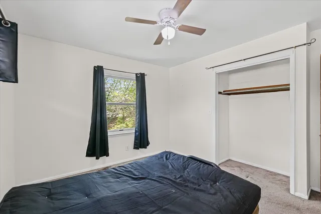 a living room with a bed and a large window
