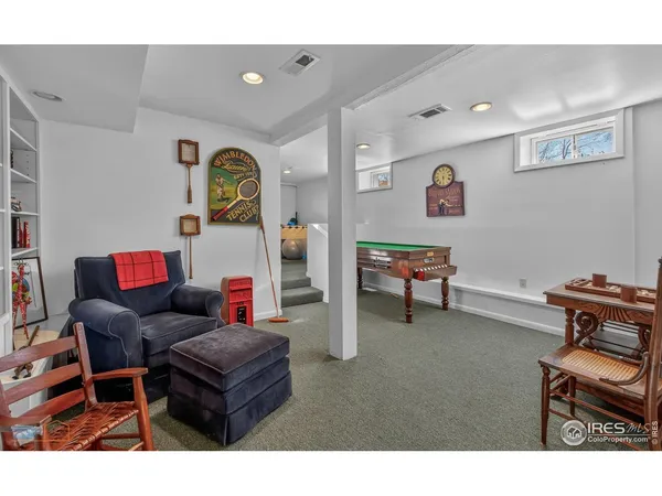 a living room with furniture a bookshelf and a window