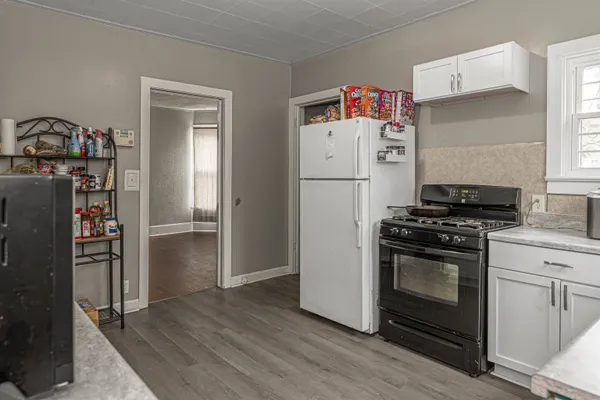 a kitchen with a refrigerator and a stove top oven