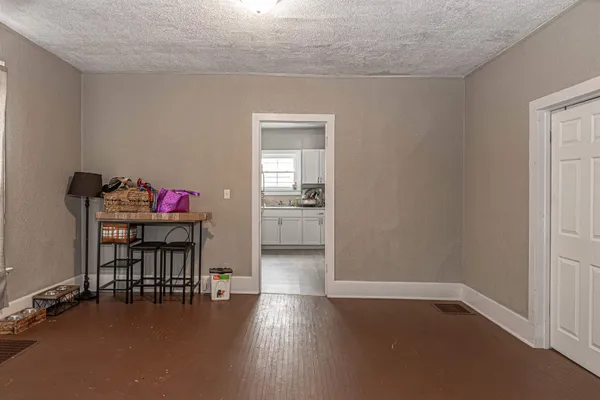an empty room with windows and cabinet