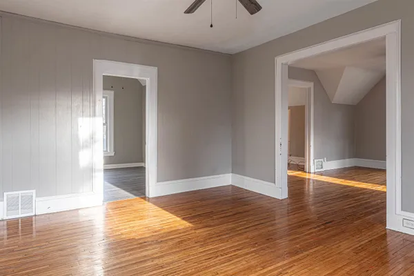 a view of empty room with wooden floor