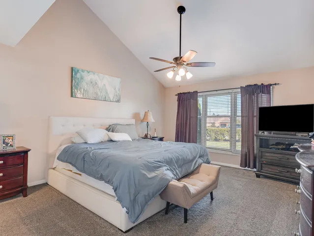 a spacious bedroom with a bed and a flat screen tv