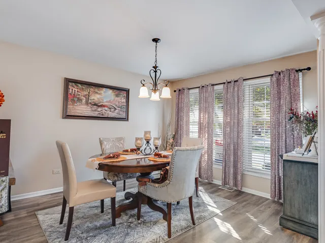 a dining room with furniture a chandelier and wooden floor