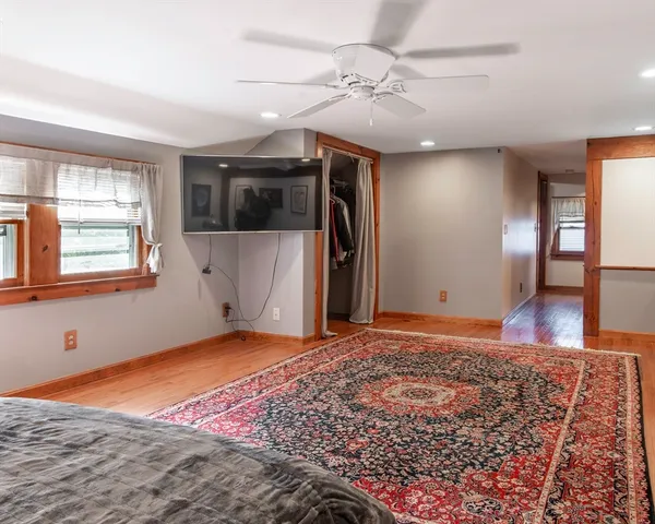 a view of an empty room with window and wooden floor