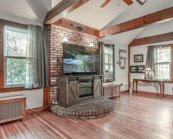 a living room with furniture a flat screen tv and a fireplace