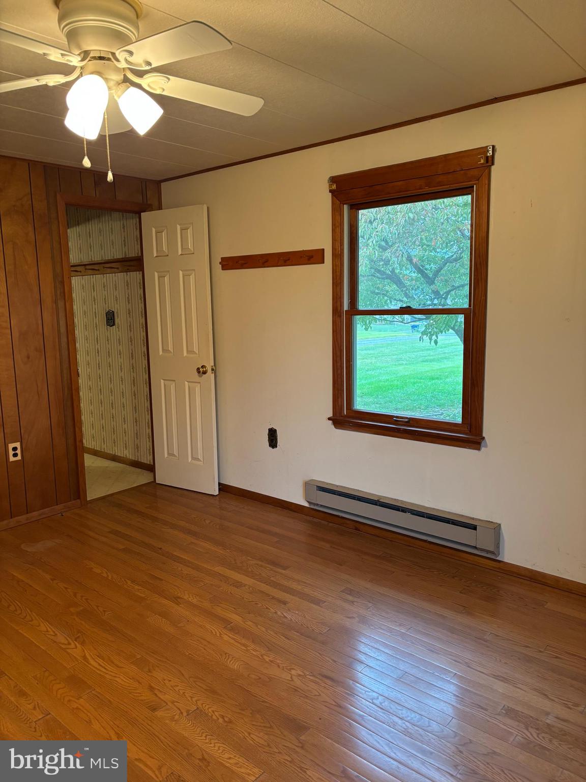 1072 Calvert Road Rising Sun, MD 21911 - Photo 14 of 17 an empty room with wooden floor chandelier fan and windows