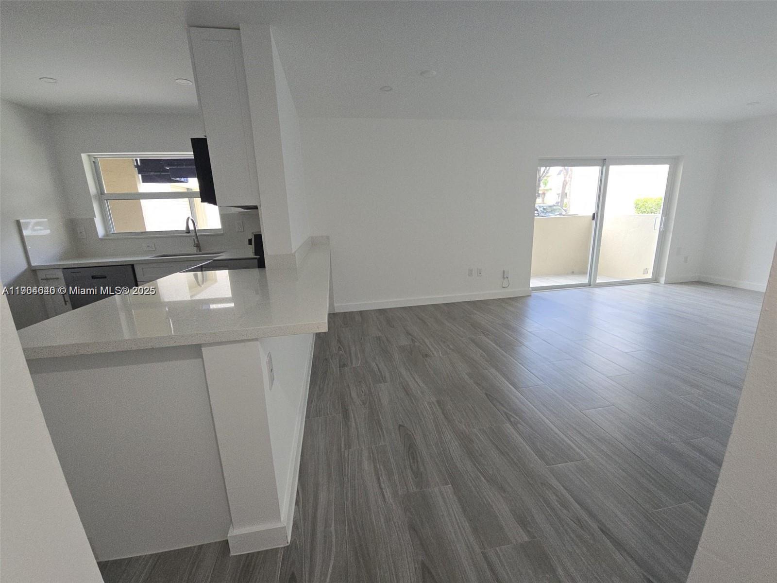 7707 Southwest 86th Street, Unit B101 Miami, FL 33143 - Photo 2 of 12 a view of a livingroom with wooden floor and a window