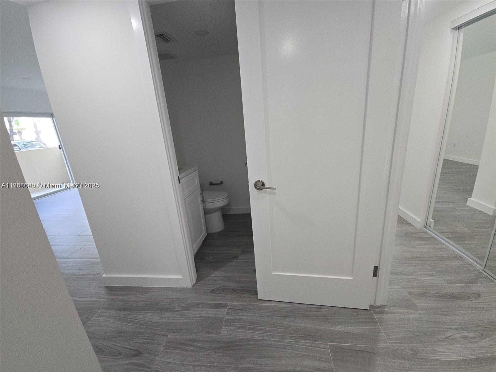 7707 Southwest 86th Street, Unit B101 Miami, FL 33143 - Photo 4 of 12 a view of a hallway with wooden floor and a hallway