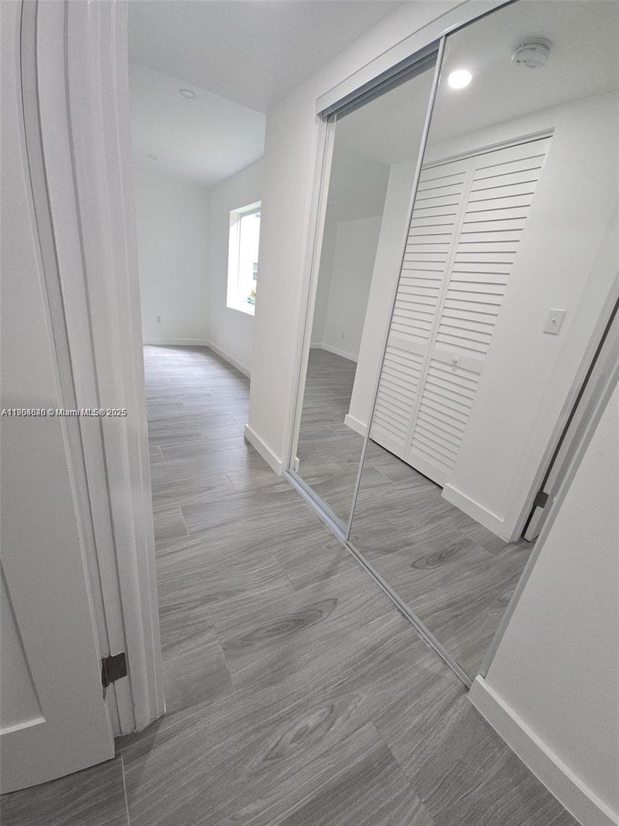 7707 Southwest 86th Street, Unit B101 Miami, FL 33143 - Photo 6 of 12 an entryway in a hall with wooden floor