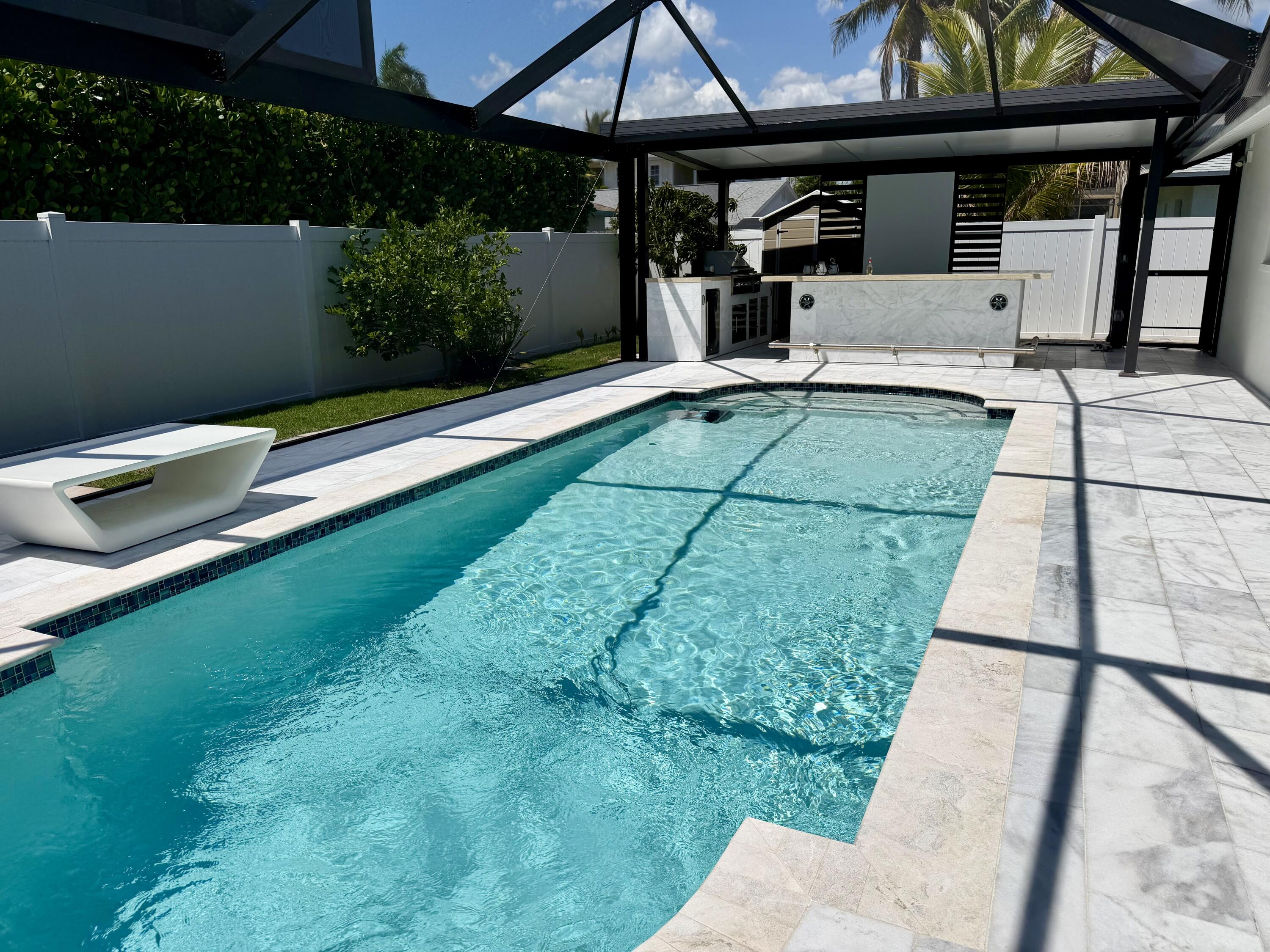 112 Capri Boulevard Naples, FL 34113 - Photo 4 of 29 a view of a patio with table and chairs under an umbrella