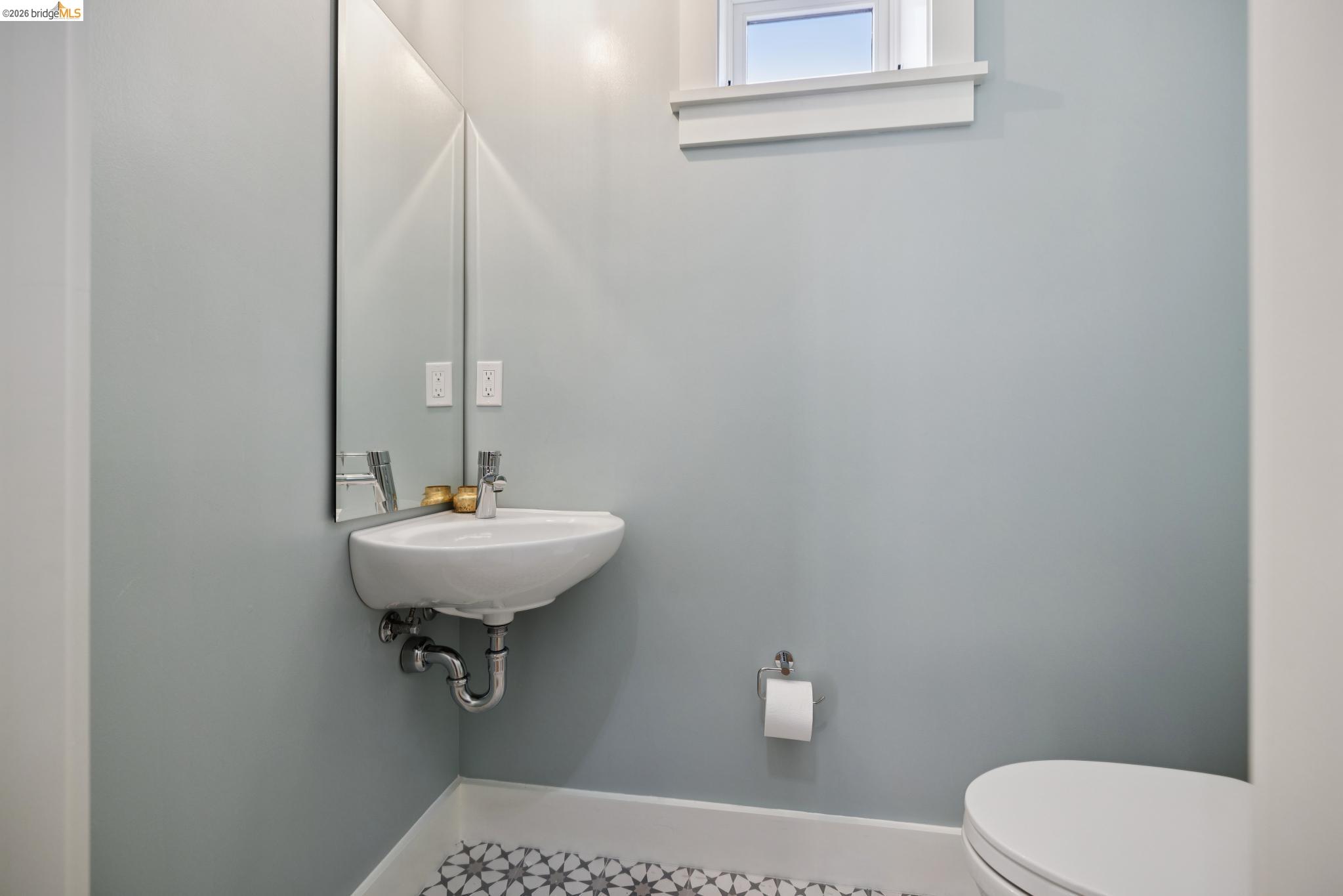 4430 Howe Street Oakland, CA 94611 - Photo 44 of 58 a bathroom with a sink a toilet and mirror