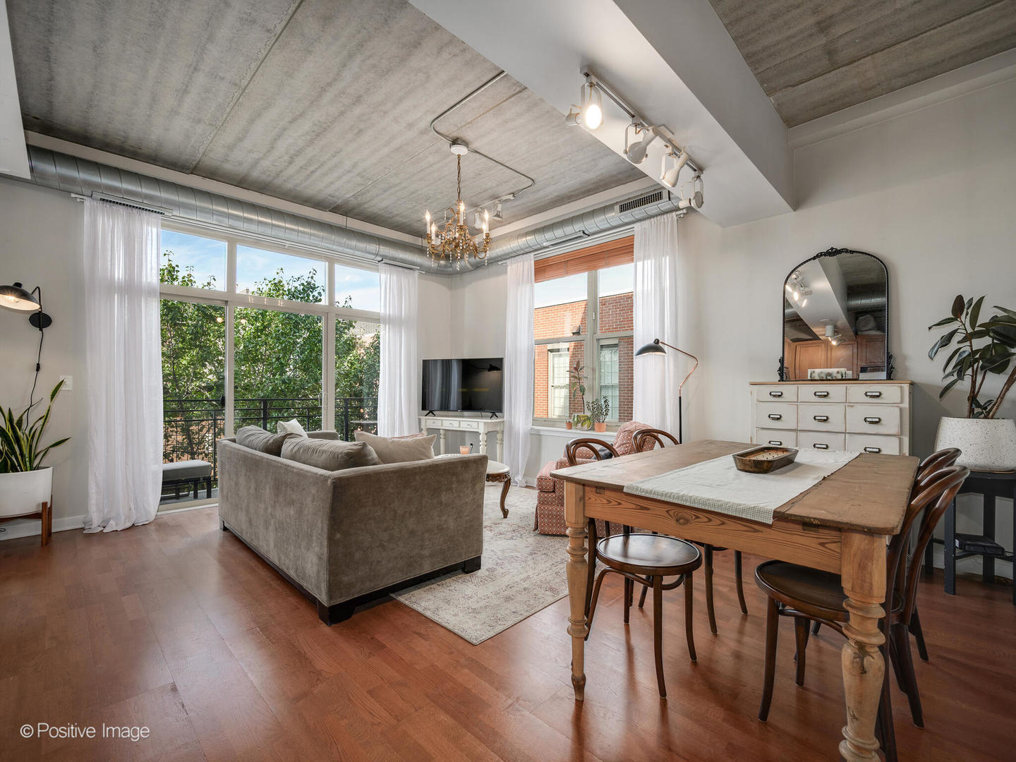1228 West Monroe Street, Unit 408 Chicago, IL 60607 - Photo 2 of 17 a living room with furniture dining table a large window and a kitchen view