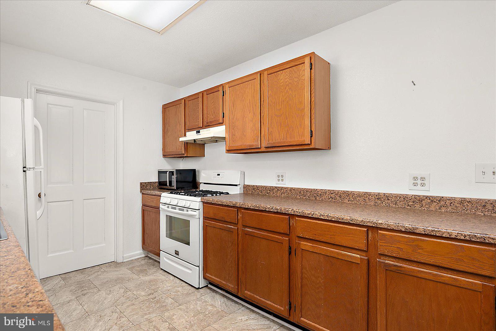 10505 Keyser Point Road Ocean City, MD 21842 - Photo 17 of 53 a kitchen with stainless steel appliances granite countertop a sink and cabinets with wooden floor