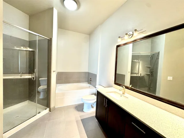 a bathroom with a large tub shower and sink