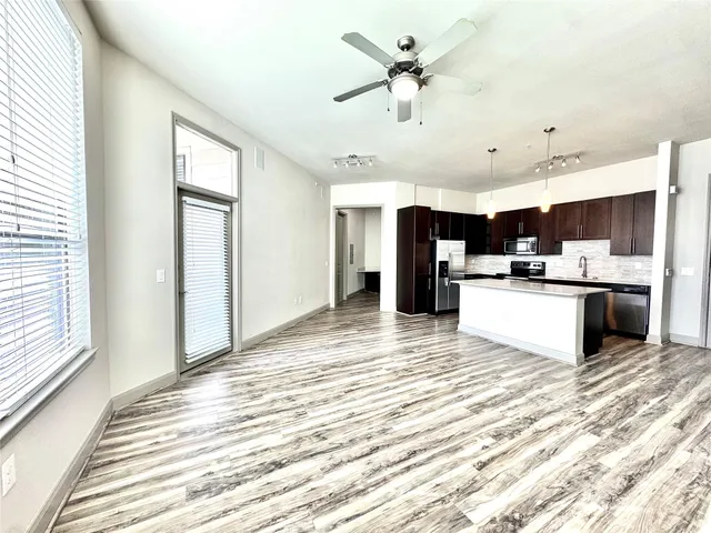 a view of kitchen with stainless steel appliances kitchen island a stove a refrigerator sink and cabinets
