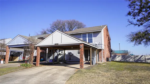 a view of a house with a patio and a yard