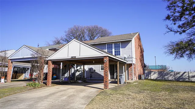 a view of a house with a patio and a yard