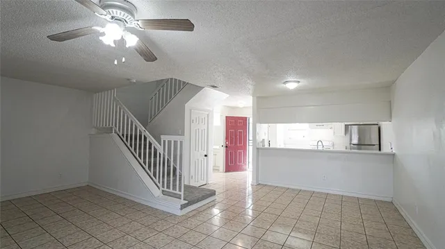 a view of a hallway with entryway and chandelier fan