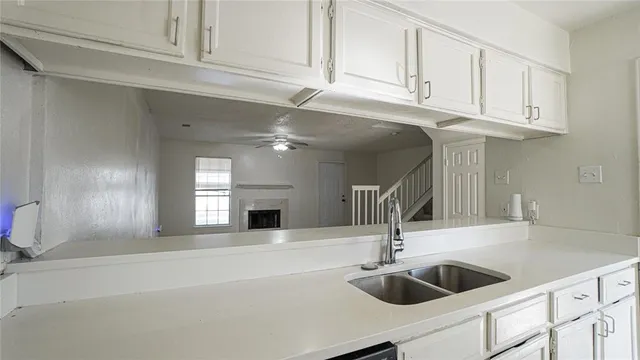 a kitchen with stainless steel appliances granite countertop a sink and white cabinets