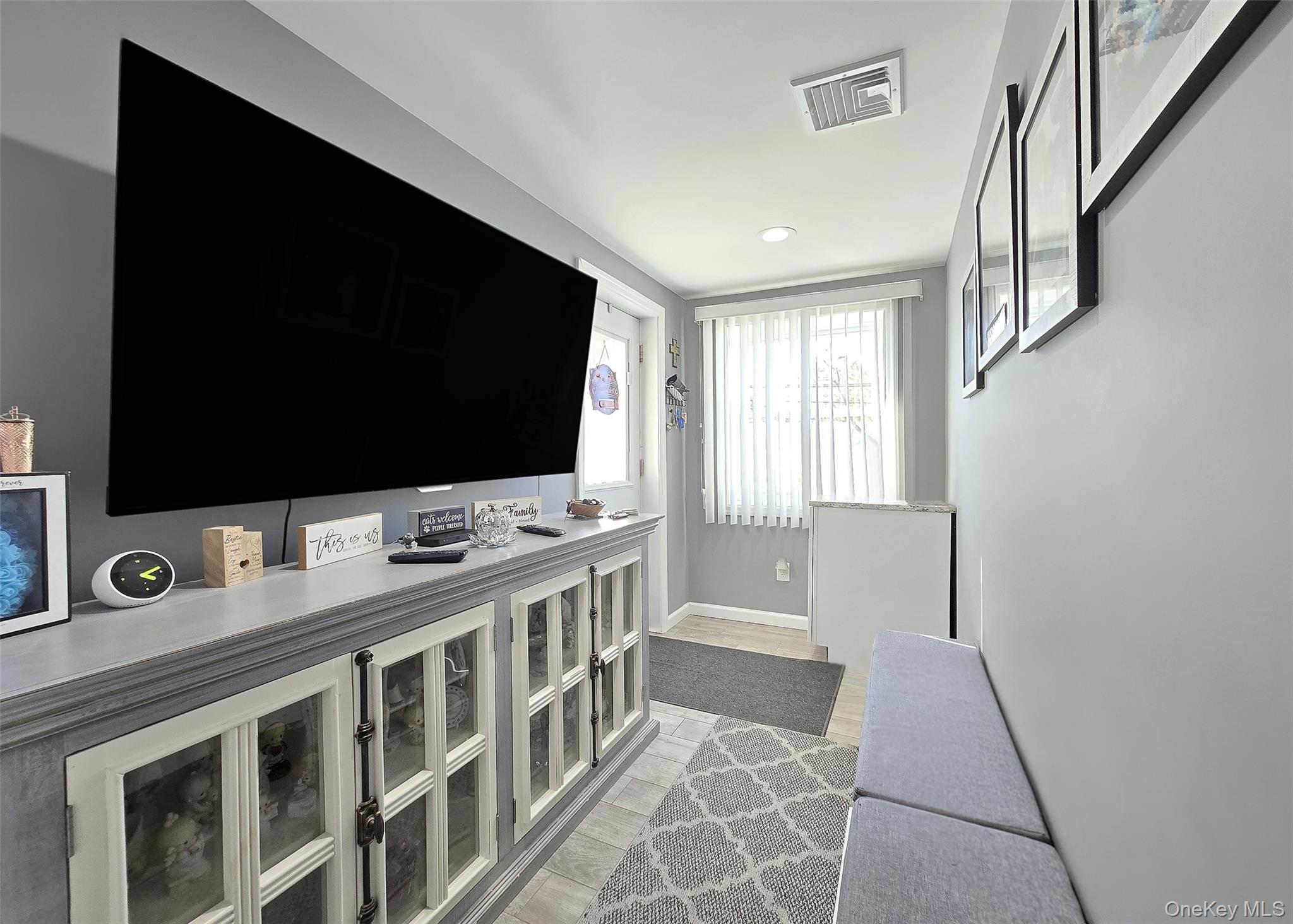 430 Heathcote Road Lindenhurst, NY 11757 - Photo 12 of 22 a living room with a flat screen tv and a fireplace