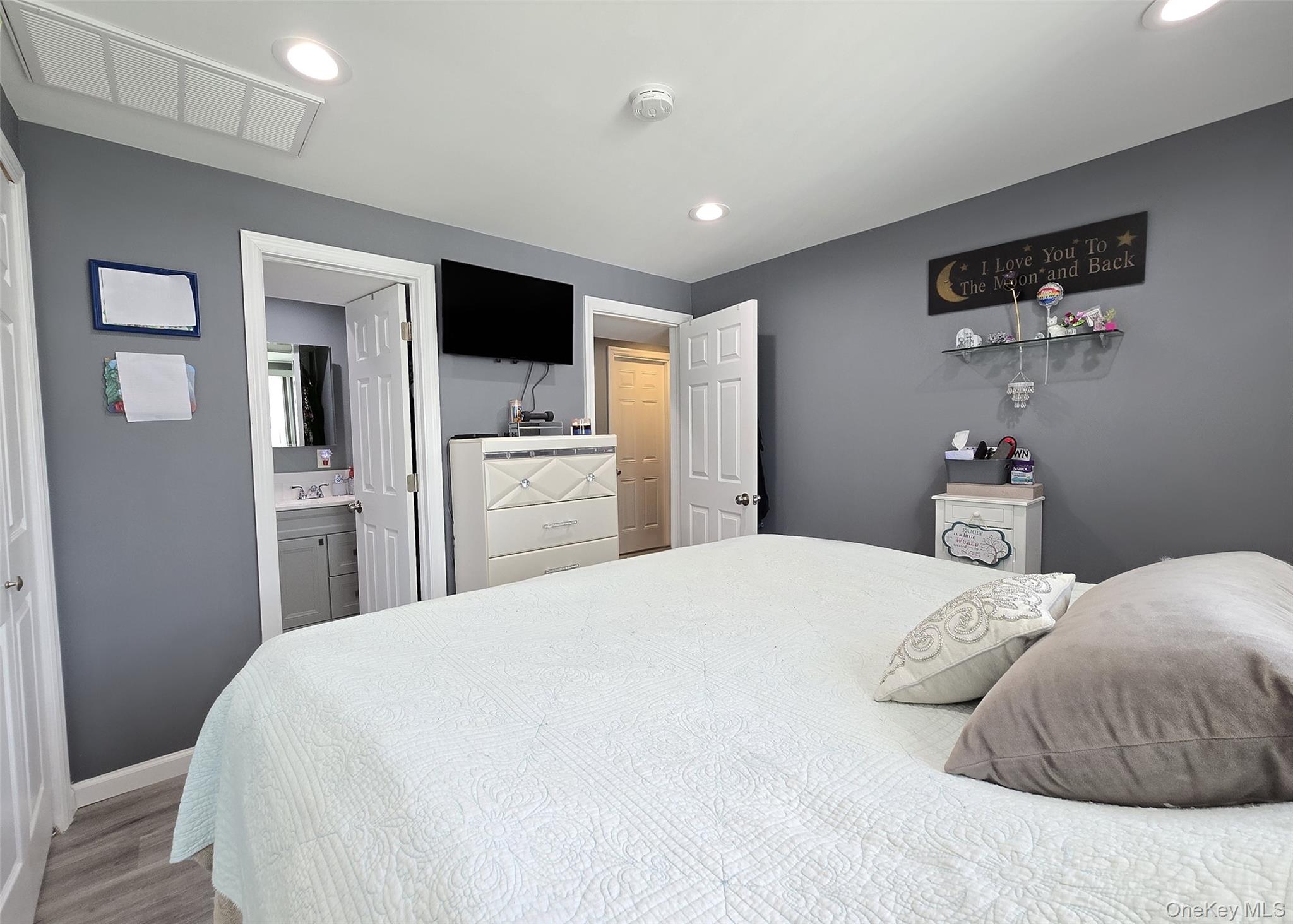 430 Heathcote Road Lindenhurst, NY 11757 - Photo 18 of 22 a bedroom with a large bed and a flat tv screen