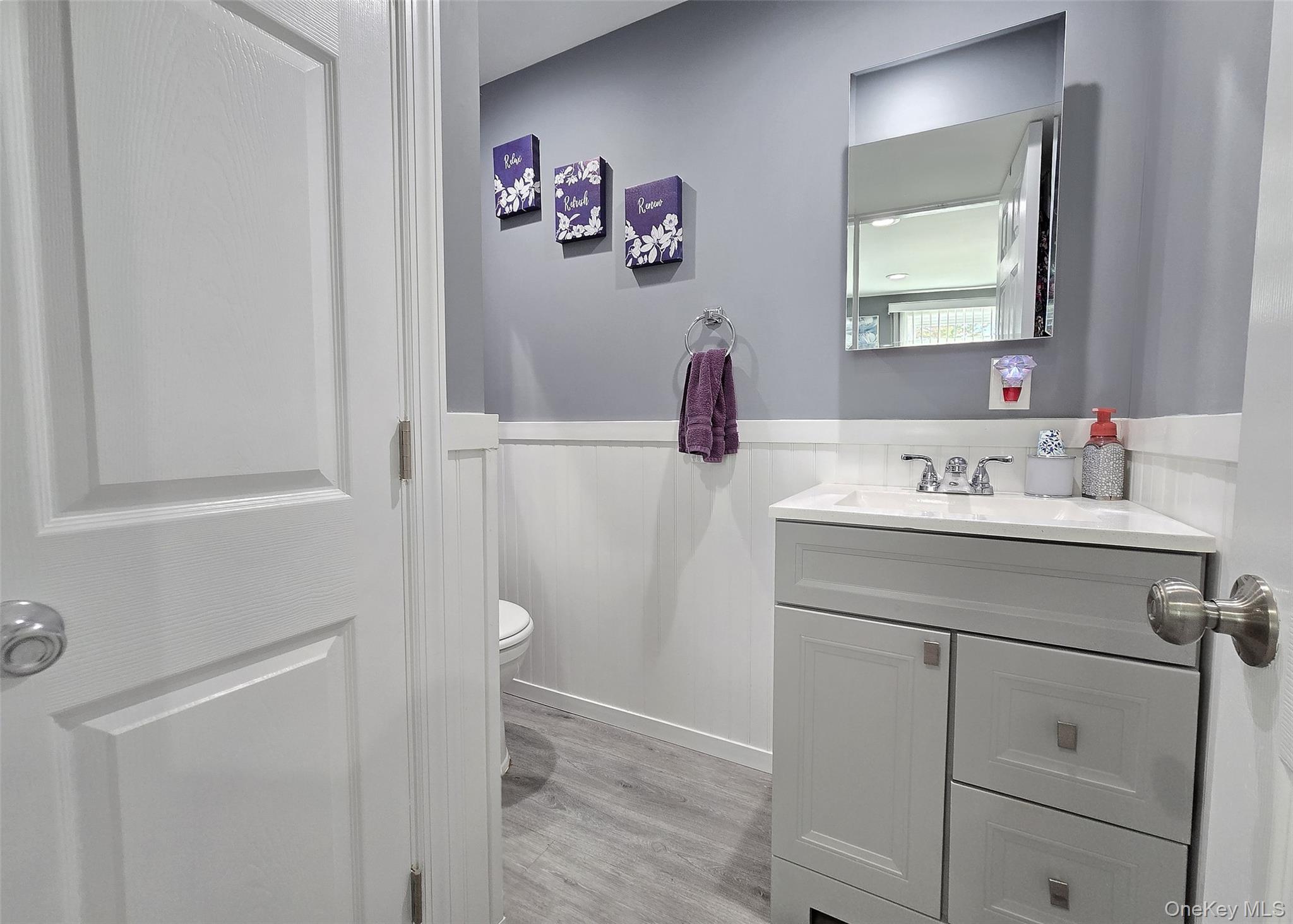 430 Heathcote Road Lindenhurst, NY 11757 - Photo 19 of 22 a bathroom with a sink and a mirror