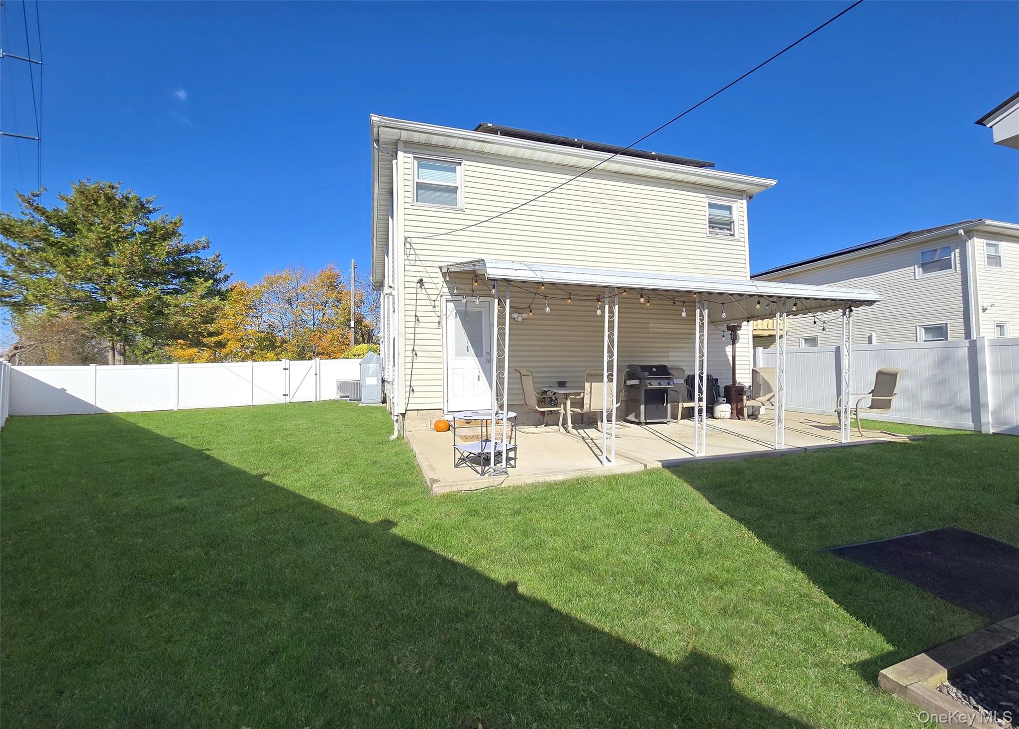 430 Heathcote Road Lindenhurst, NY 11757 - Photo 21 of 22 a view of backyard of house with outdoor seating and green space