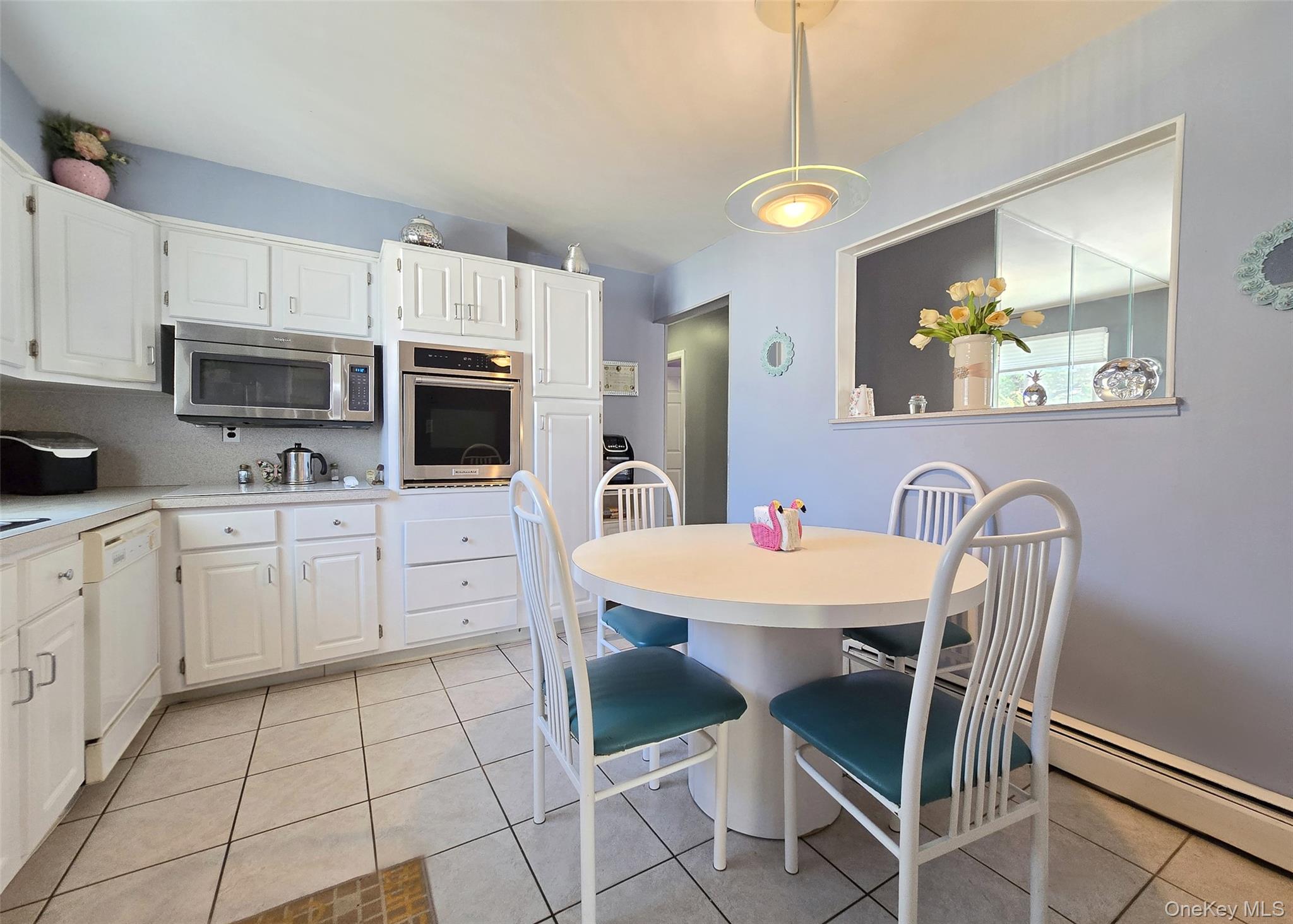 430 Heathcote Road Lindenhurst, NY 11757 - Photo 5 of 22 a kitchen with stainless steel appliances a stove a microwave a sink a dining table and chairs