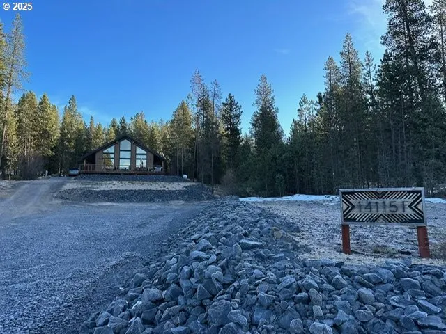 a view of a backyard with wooden fence and trees