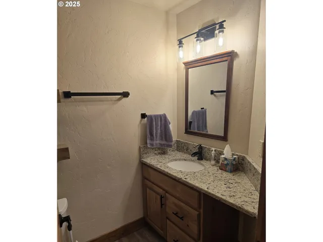 a bathroom with a granite countertop sink and a mirror