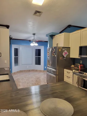 a kitchen with stainless steel appliances granite countertop a sink a stove and a refrigerator