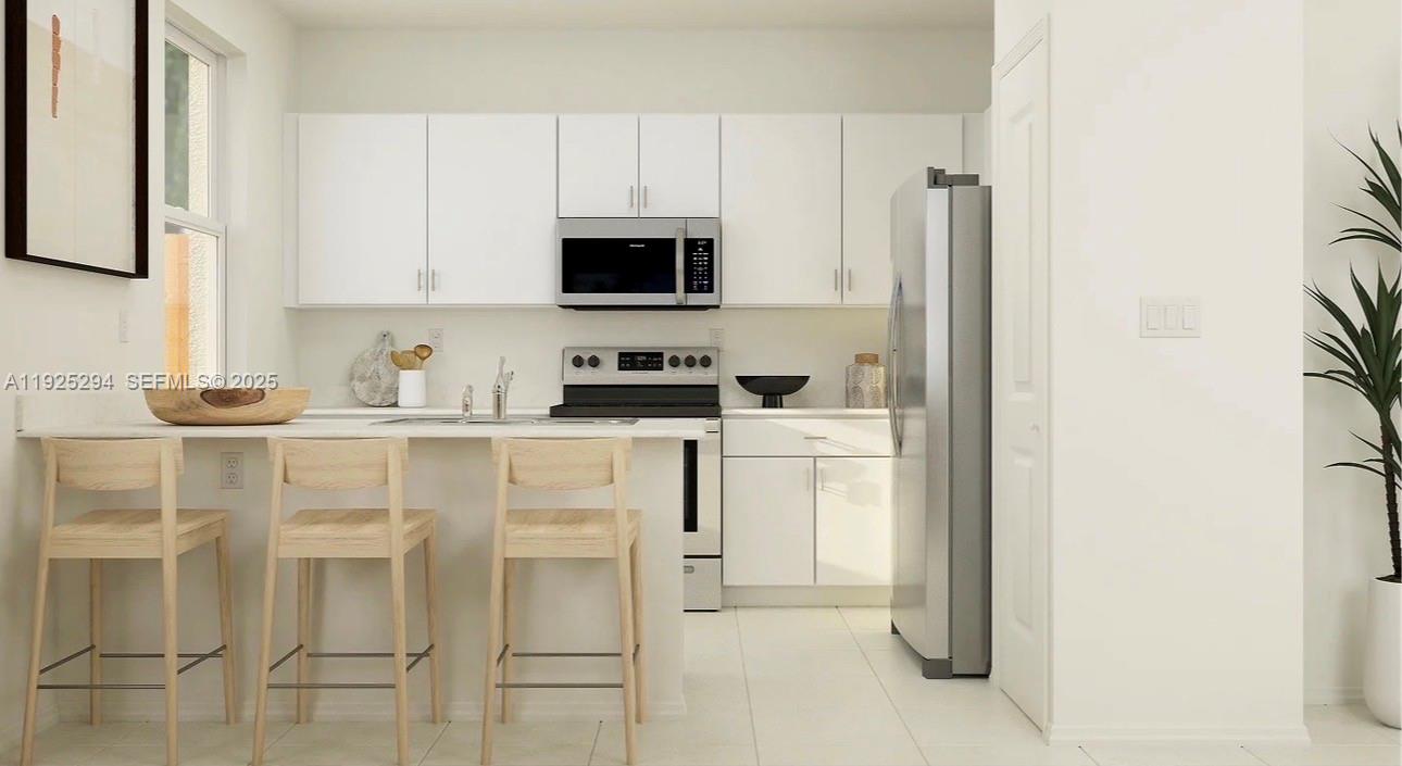 2538 Southeast 29th Street Homestead, FL 33035 - Photo 2 of 9 a kitchen with white cabinets and stainless steel appliances