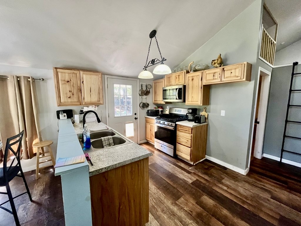 114 Elm Branch Street Huntington, TX 75949 - Photo 5 of 14 a kitchen with stainless steel appliances a stove a refrigerator a sink a stove and white cabinets with wooden floor