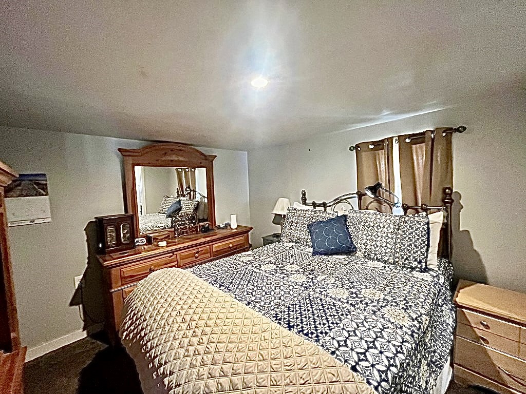 114 Elm Branch Street Huntington, TX 75949 - Photo 7 of 14 a bedroom with a large bed and wooden floor