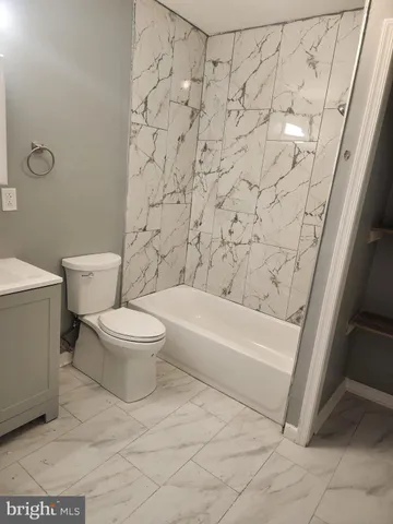 a white toilet sitting next to a bath tub and a shower