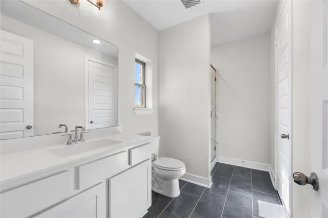 a bathroom with a sink a toilet and a large mirror