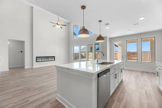 a kitchen with granite countertop a sink and a stove with wooden floor