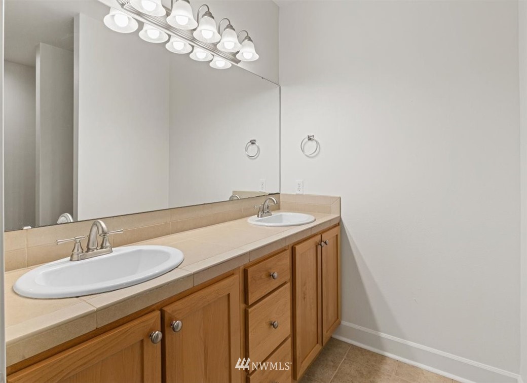 19102 20th Drive Southeast, Unit B206 Bothell, WA 98012 - Photo 17 of 29 a bathroom with a sink a mirror and a light fixture