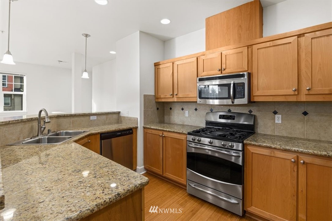 19102 20th Drive Southeast, Unit B206 Bothell, WA 98012 - Photo 9 of 29 a kitchen with stainless steel appliances granite countertop a sink stove and microwave