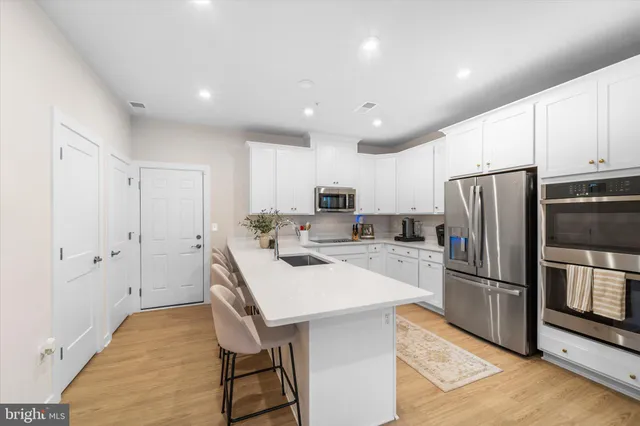 a kitchen with kitchen island a counter space stainless steel appliances and cabinets
