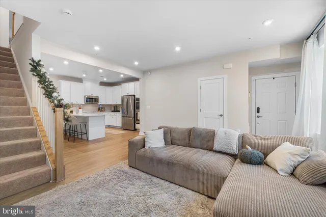 a living room with furniture and a view of kitchen