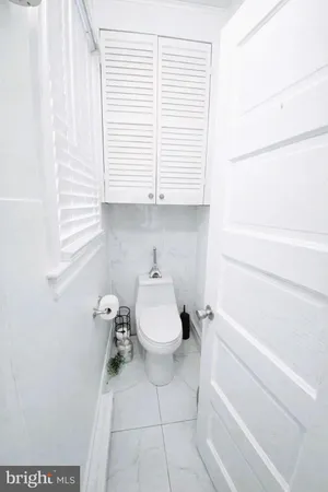 a bathroom with a toilet a sink and a window