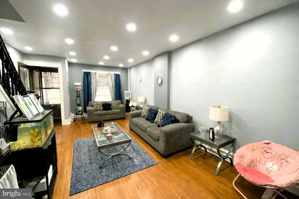 a living room with furniture a rug and gym equipment