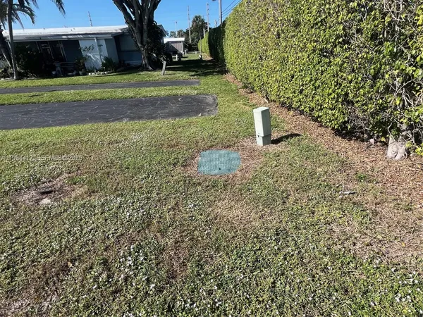 a green field with trees in the background