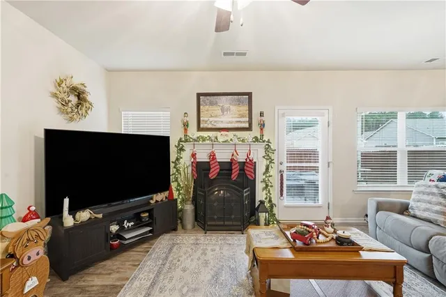 a living room with furniture a flat screen tv and a window