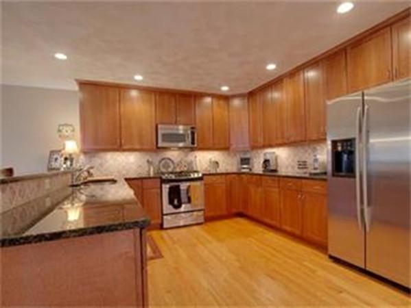 25 Maple Street, Unit 2 Needham, MA 02492 - Photo 8 of 11 a kitchen with granite countertop a sink stainless steel appliances and cabinets