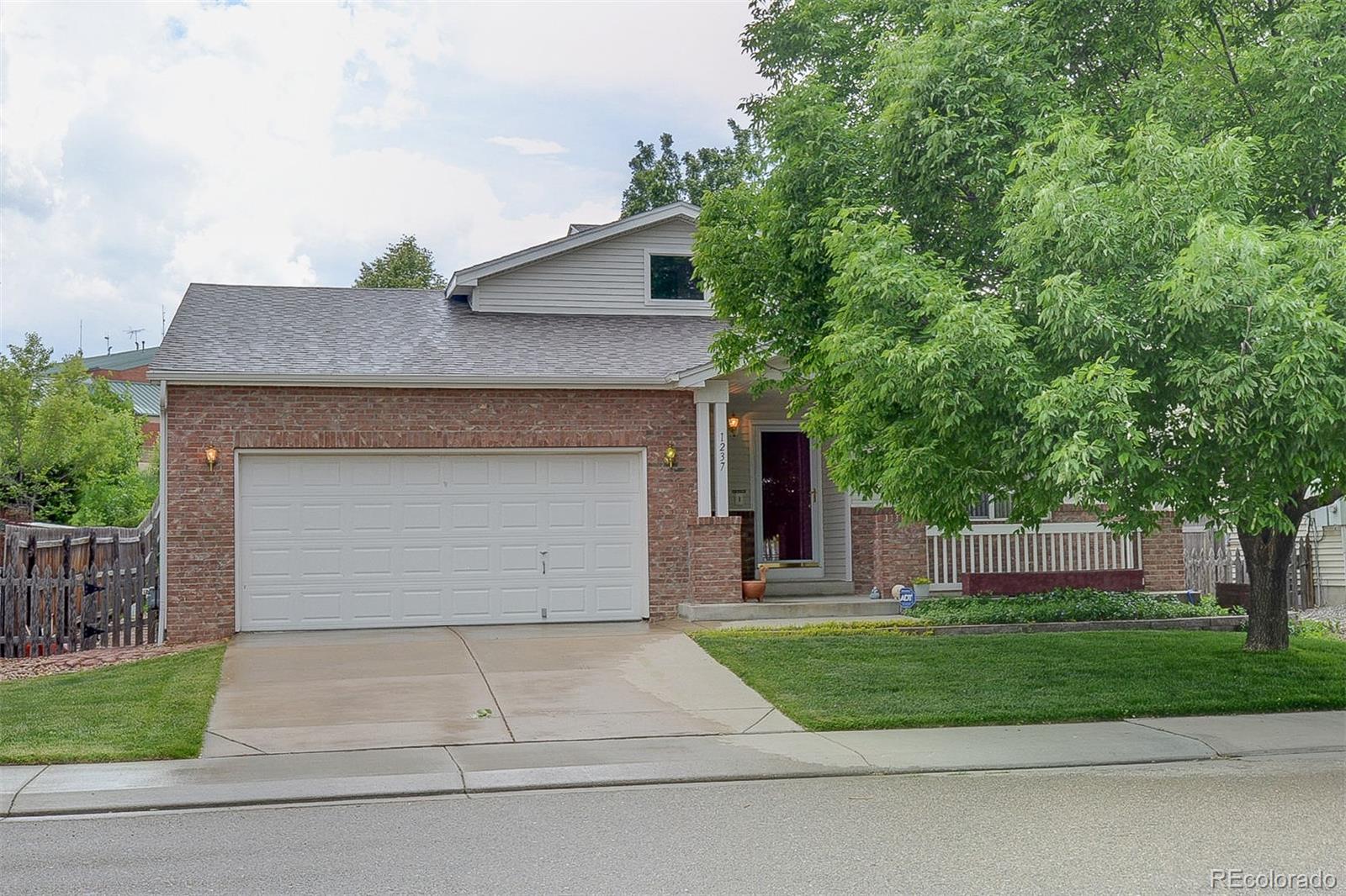 a front view of a house with a garden and garage