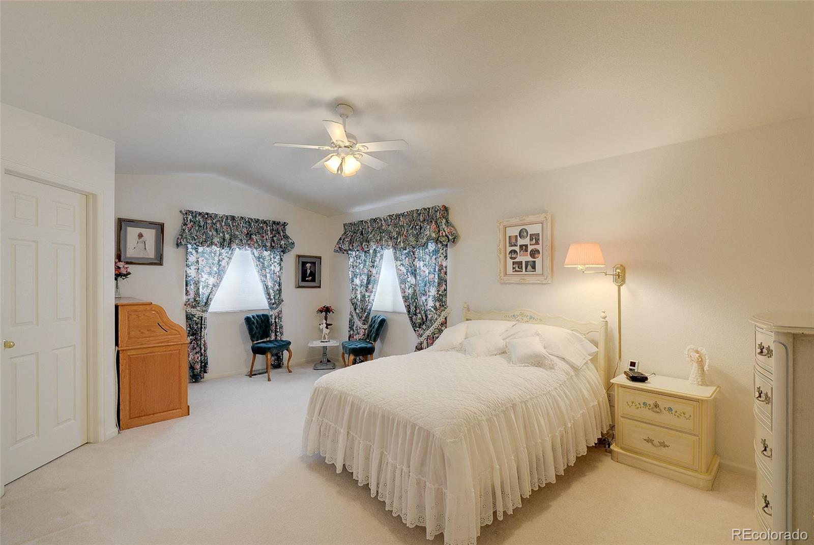 1237 Trail Ridge Road Longmont, CO 80504 - Photo 19 of 34 a bedroom with a large bed and a chandelier