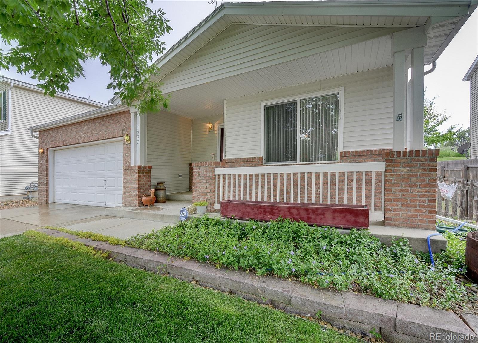 1237 Trail Ridge Road Longmont, CO 80504 - Photo 3 of 34 a view of a house with a yard and flower plants