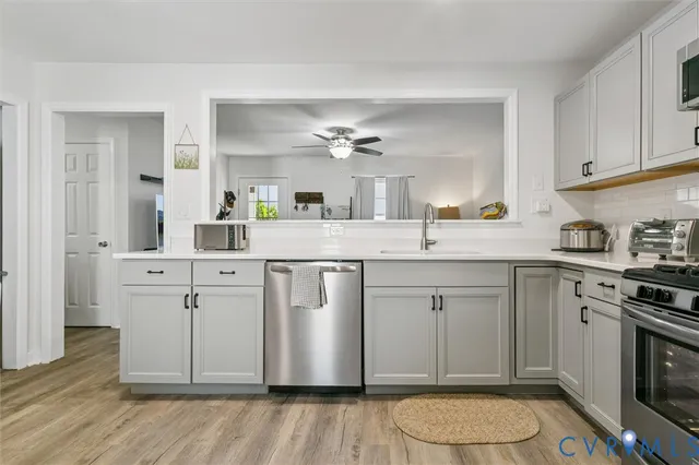 a kitchen with a sink cabinets and wooden floor